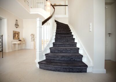 Klassische Betontreppe mit weiß lackierten Holzstufen